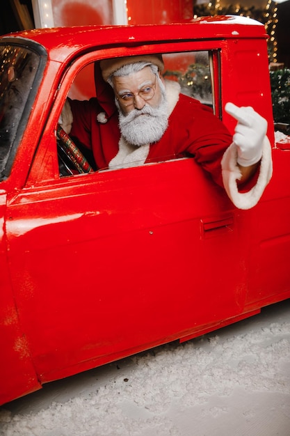 De kerstman bereidt zich voor op Kerstmis Boos ontevreden geërgerd stijlvol rijden in een rode auto