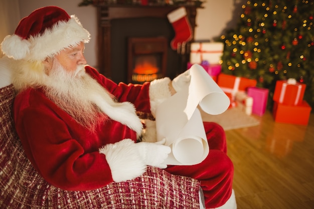 De kerstman die zijn lijst leest bij kerstmis