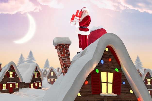 De kerstman draagt een stapel geschenken tegen een schattig kerstdorp onder de halve maan
