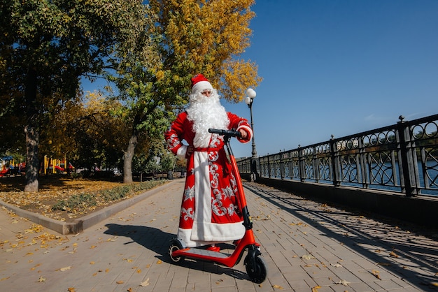 De kerstman heeft haast op een scooter met cadeautjes voor de vakantie aan de kinderen.