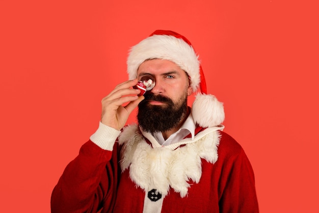 De kerstman houdt een kristallen bol kerstsneeuwbol in de hand bebaarde kerstman met kleine kerstsneeuw