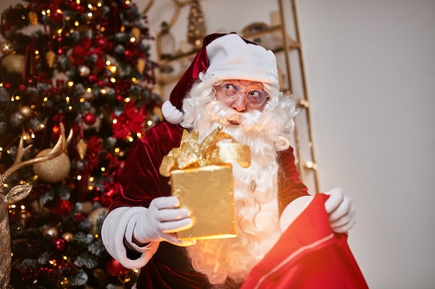 De kerstman met een grote rode zak met cadeaus haast zich om cadeau te brengen aan kinderen.