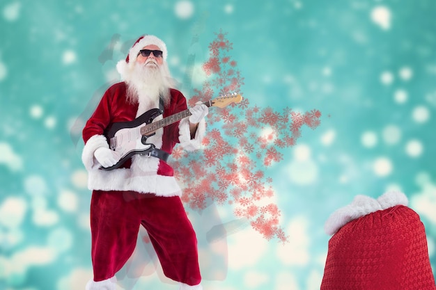 De kerstman speelt gitaar met een zonnebril tegen een lichtontwerp dat op blauw glinstert