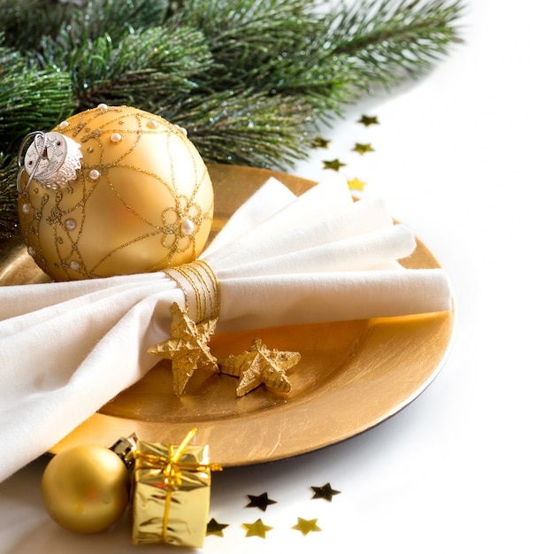 De Kerstmislijst die in gouden met Kerstmisdecoratie en takken plaatsen dicht omhoog geïsoleerd op wit