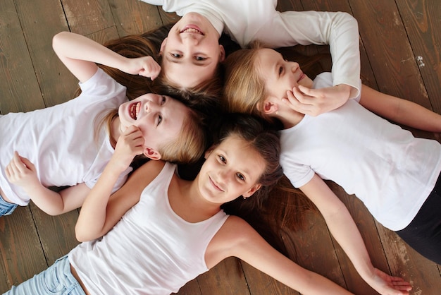 De kinderen gaan in een kring. Vier meisjes op de houten vloer, bovenaanzicht.