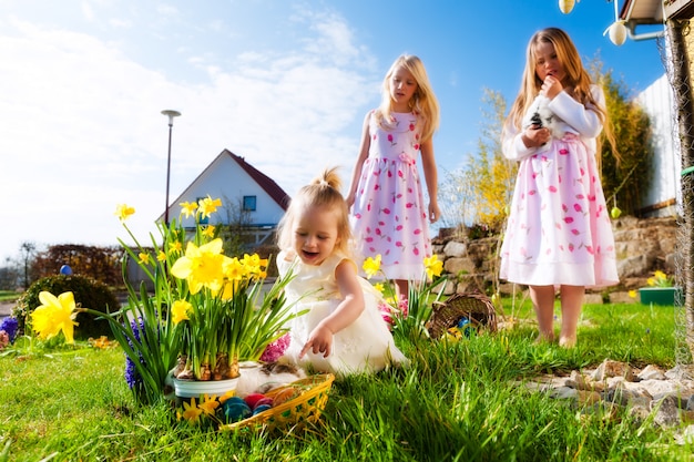 De kinderen op paasei jagen met konijntje