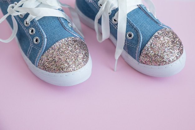 De kinderschoenen van het denim met kant op roze achtergrond