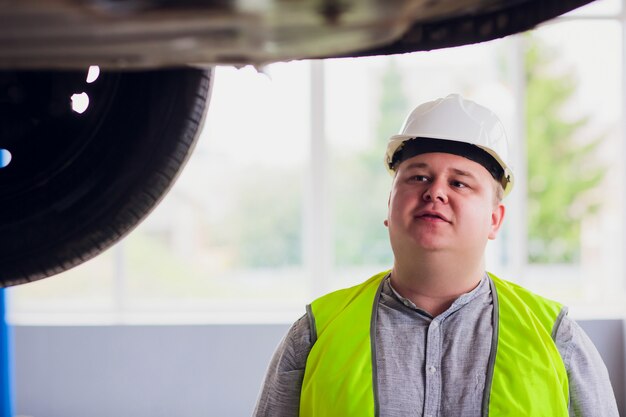 De klant bekijkt het werk in een wiel van de autoworkshop onder auto in dienst