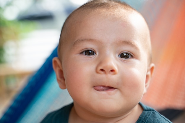 De kleine jongen die in de hangmat zit.