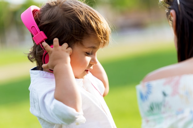 De kleine jongen luistert naar muziek in het park.