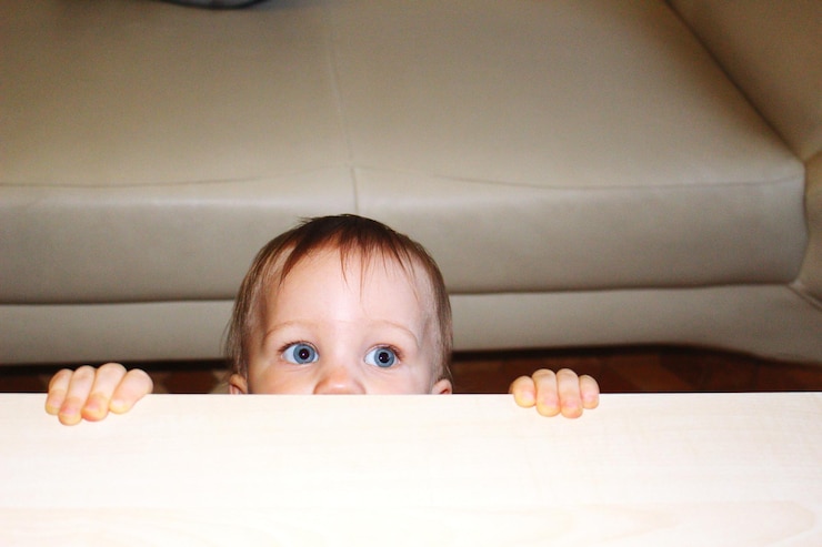 Foto de kleine jongen onder de tafel.