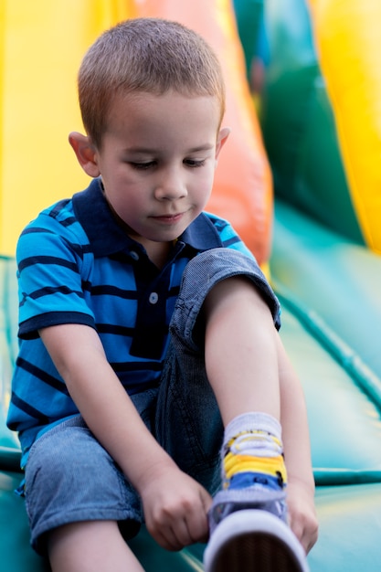 Foto de kleine jongen zet op zijn schoenen