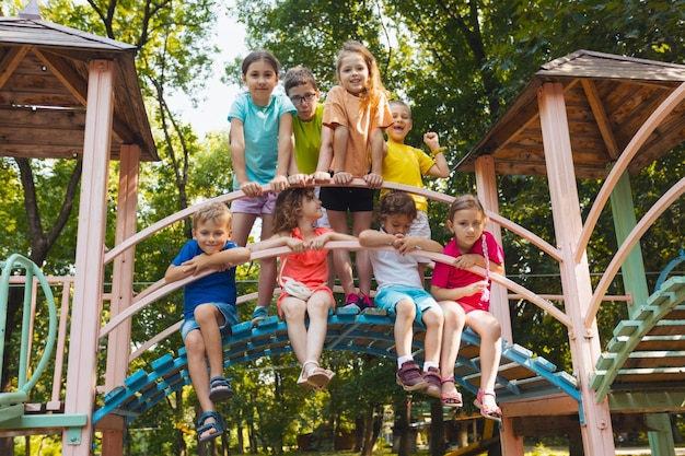 De kleine kinderen in de speeltuin duimen omhoog