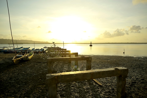 Foto de kleine vastgelegde vissersboten beached op de verlaten haven tijdens de zonsondergang