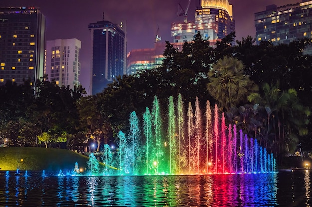 De kleurrijke fontein op het meer bij nacht met stad op achtergrond kuala lumpur maleisië