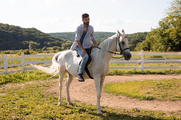 De knappe man rijdt op een paard op een ranch