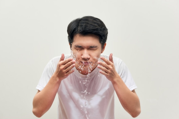 De knappe mens wast zijn gezicht