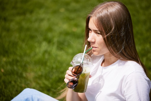 De koele matchacocktail houdt ter beschikking op hemelachtergrond met zonnig weer