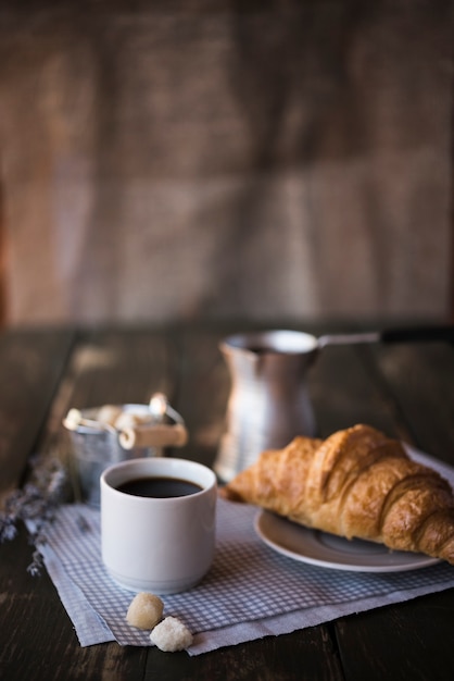 Foto de koffie en het croissant van het ochtendontbijt op exemplaar ruimteachtergrond