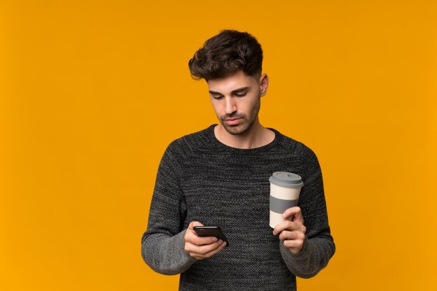 De koffie van de jonge mensenholding om weg te nemen en mobiel