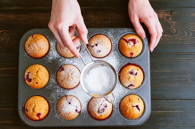 De kok bestrooit muffins