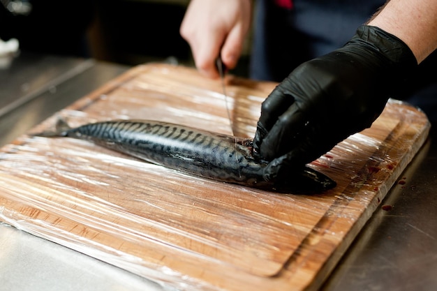 De kok scheidt de filet van de vis en ontdoet hem van de botten Makreelfilets