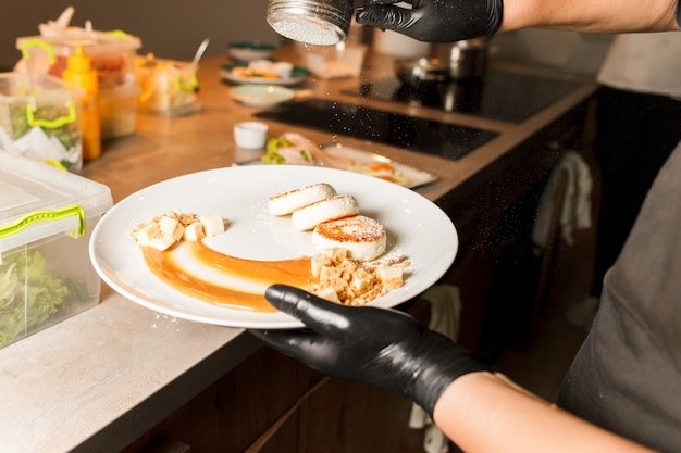 De kok van het restaurant heeft heerlijke kaaspannenkoekjes bereid en bestrooid met poeder