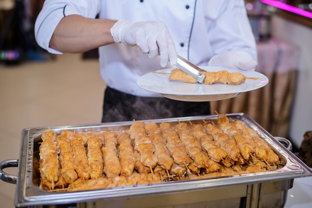 De kok zet het bord met kip kebab