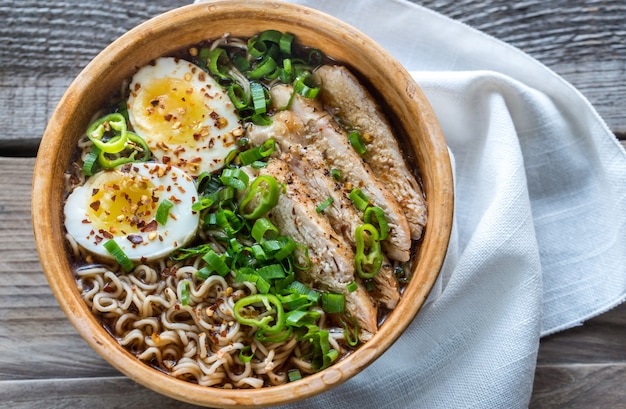 De kom kip ramen soep op de houten lijst