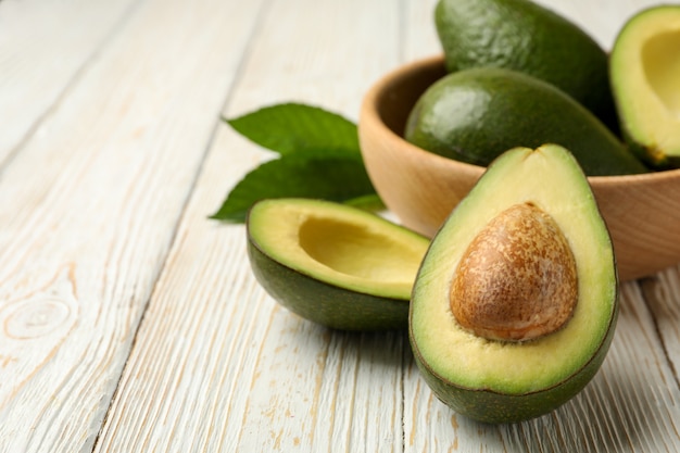 De kom met verse avocado op houten lijst, sluit omhoog