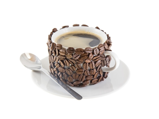 De kop koffie en lepel, versierd met koffiekorrels. Geïsoleerd
