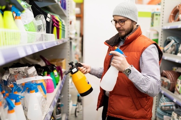 Foto de koper in de winkel kiest een spuitfles