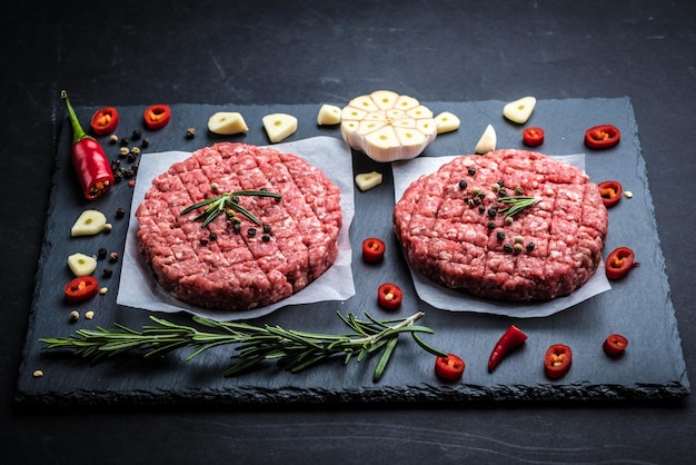 De koteletten van de rauw vleesburger met ingrediënten