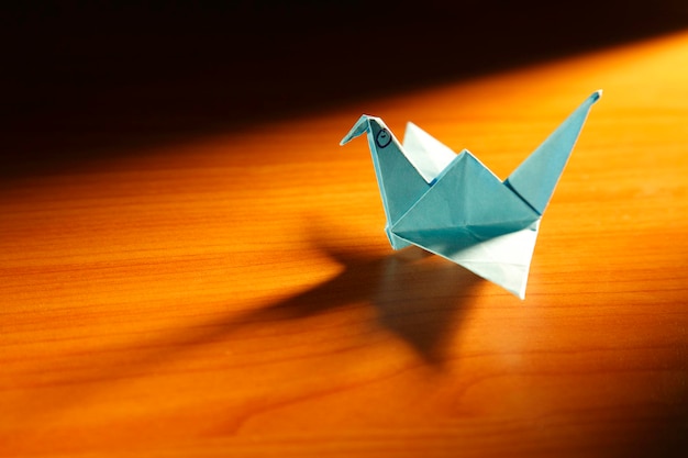De kraanvogel van de origamivogel op bruine achtergrond