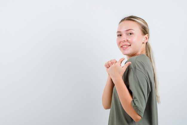 De lachende blonde vrouw toont een groottegebaar op een witte achtergrondxDxA