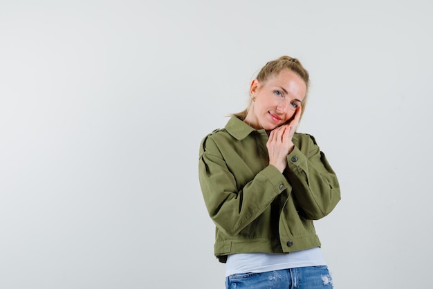 De lachende vrouw houdt haar handen op de wang op een witte achtergrond