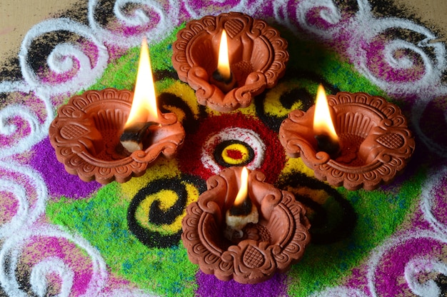 Foto de lampen van kleidya die tijdens diwaliviering worden aangestoken, rangoli op achtergrond