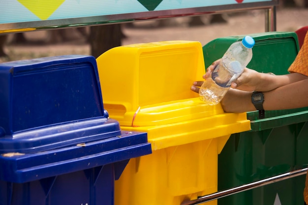 De leerlingen houden een plastic waterfles vast om in de driekleurige prullenbak te doen
