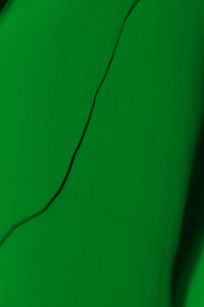 De lekkende textuur van de groene verf Bevlekte verf is een vloeibare groene kleur Achtergrond groene kleur uitval verspreidt zich in het licht Toegepast op het oppervlak grasachtig natuurlijk