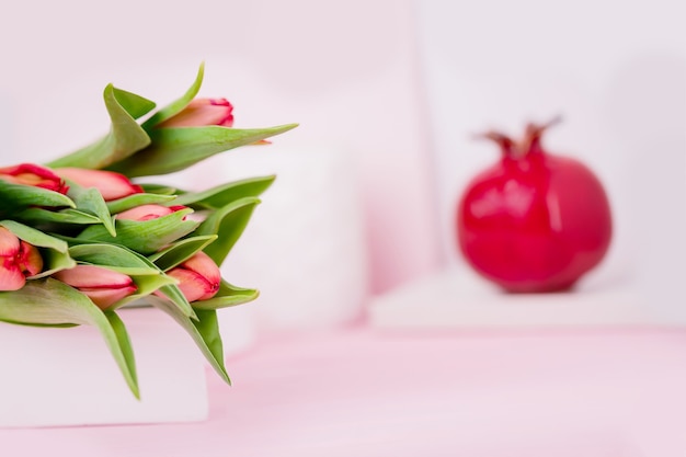 De lente bloeit rode tulpen en keramisch granaatappelfruit