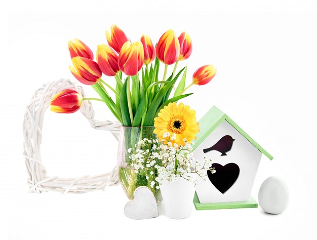 De lentesamenstelling met bloemen, het nestelen doos, ei en hart, op wit wordt geïsoleerd dat