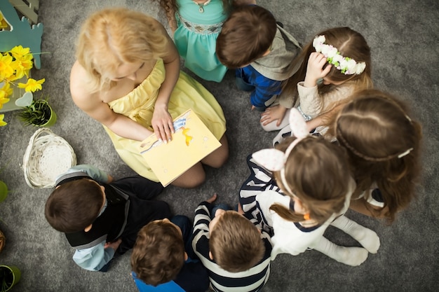 De leraar leest een boek voor kinderen