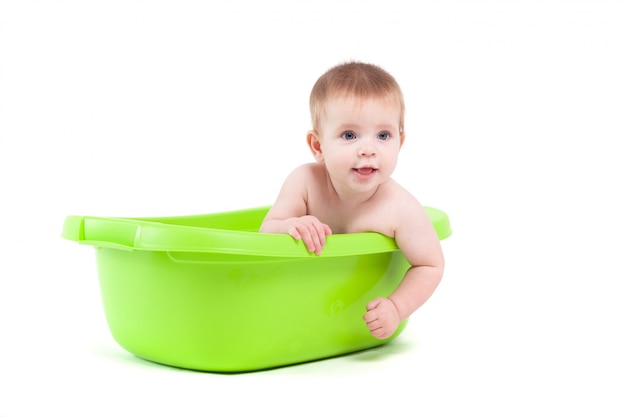 De leuke aantrekkelijke babyjongen neemt bad in ton