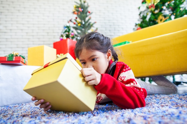 De leuke Aziatische verrassing van het kindmeisje met gift en het houden van mooie giftdoos op Kerstmisviering in hand