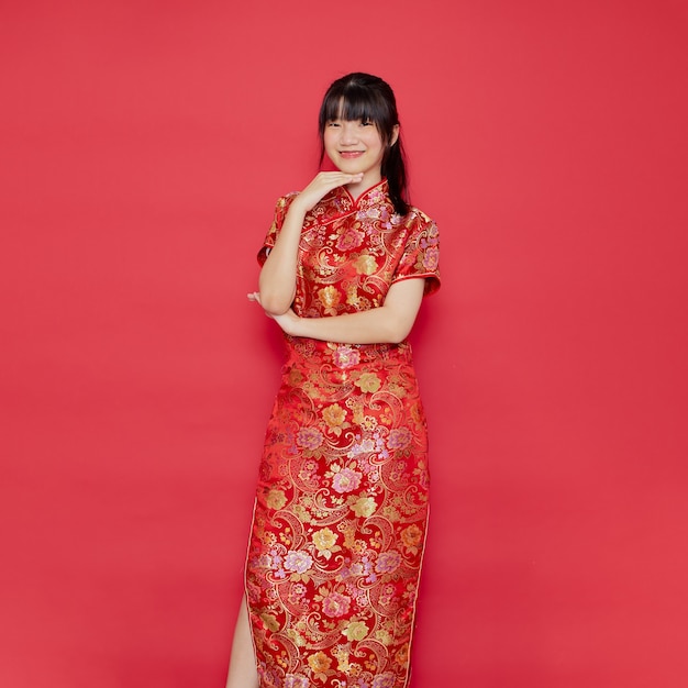 De leuke jonge Aziatische cheongsam van de vrouwenkleding met actie voor Chinees nieuwjaarconcept