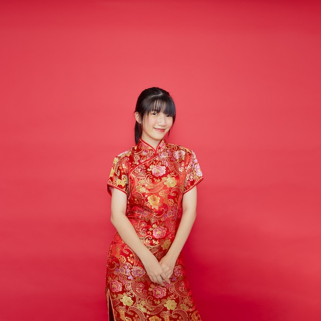 De leuke jonge Aziatische cheongsam van de vrouwenkleding met actie voor Chinees nieuwjaarconcept