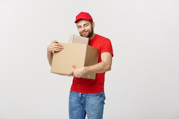 De leveringsmens van het portret in GLB met rood t-shirt die als koerier of handelaar werken die twee lege kartondozen houden.