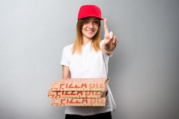 De leveringsvrouw die van de pizza op geweven achtergrond telt