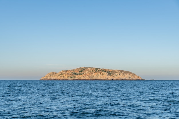 De lucht is helder en blauw, het eiland midden in de zee