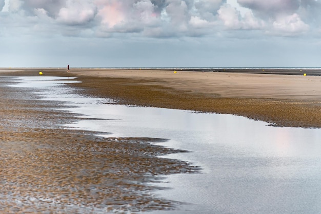 De lucht van de vroege ochtend wordt weerspiegeld in de plassen water die door het eb zijn achtergelaten